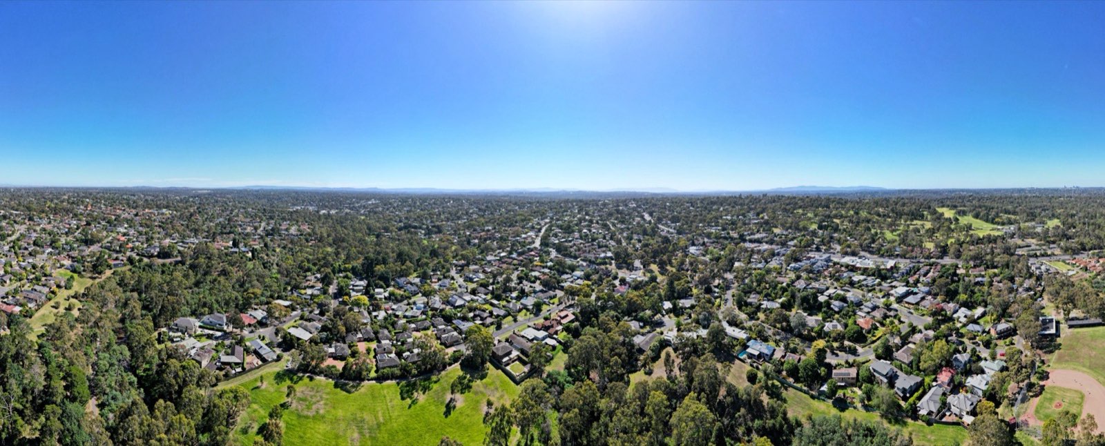 Aerial view across the Plenty valley toward the tree-covered hills of Montmorency and Eltham